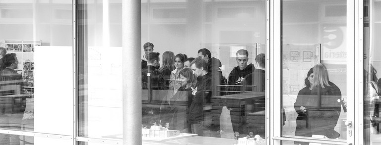 Foto einer Präsentation in einem Pavillon mit Menschen, die sich die Präsentation anschauen 