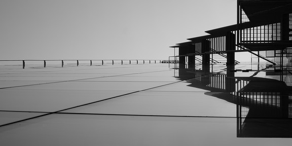 schwarz weiß Bild einer Brücke im Wasser